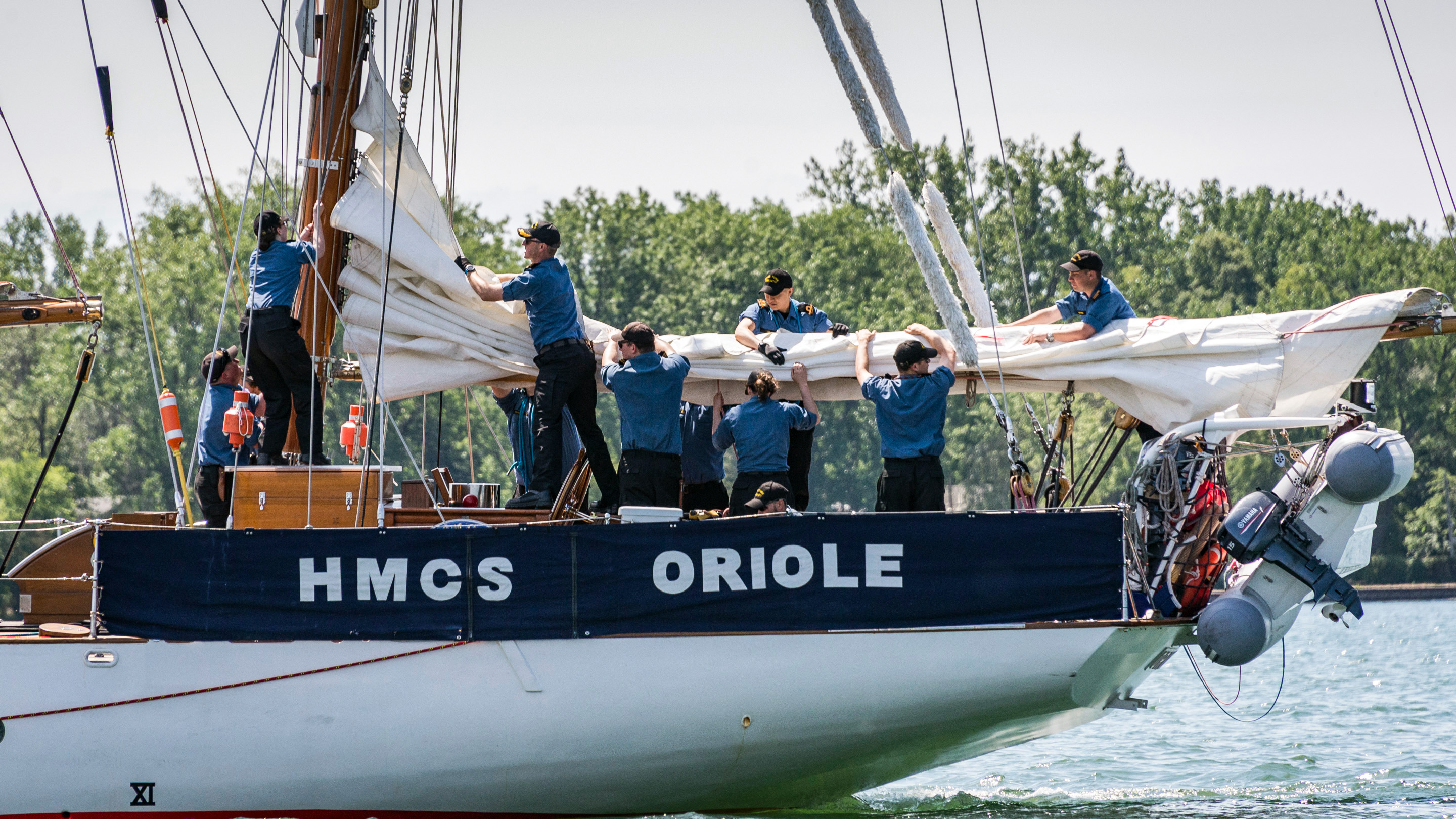 Slide - Crewmembers aboard the HMCS Oriole flake and secure the mizzen sail 