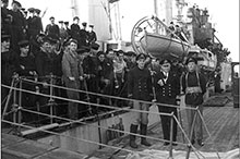 Rear-Admiral L.W. Murray, Flag Officer Newfoundland, greets the crew of the destroyer Assiniboine at St. John’s after their sinking of U-210 on 6 August 1942; the ship’s captain, Lieutenant- Commander John Stubbs (right), would be lost with his  next ship, Athabaskan.