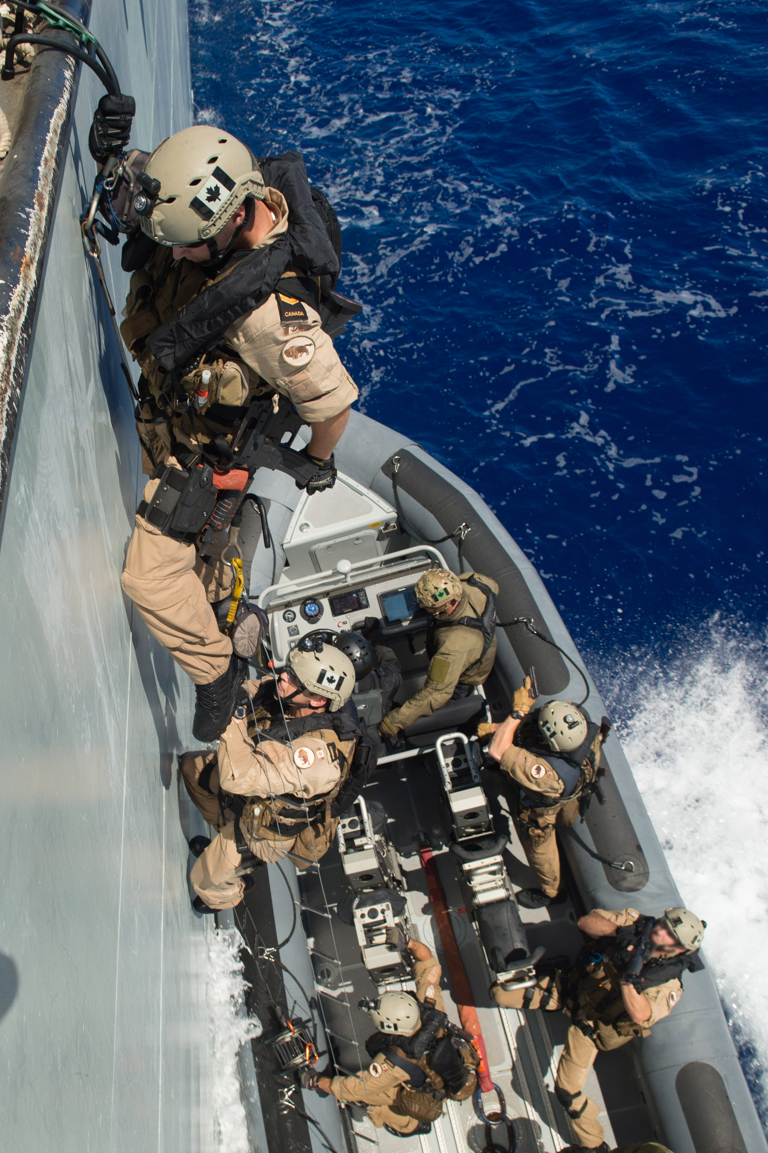A member of the Enhanced Naval Boarding Party climbs aboard Her Majesty’s Canadian Ship WINNIPEG from a rigid hull inflatable boat during Operation REASSURANCE on July 8, 2015. (Photo has been digitally altered due to OPSEC)