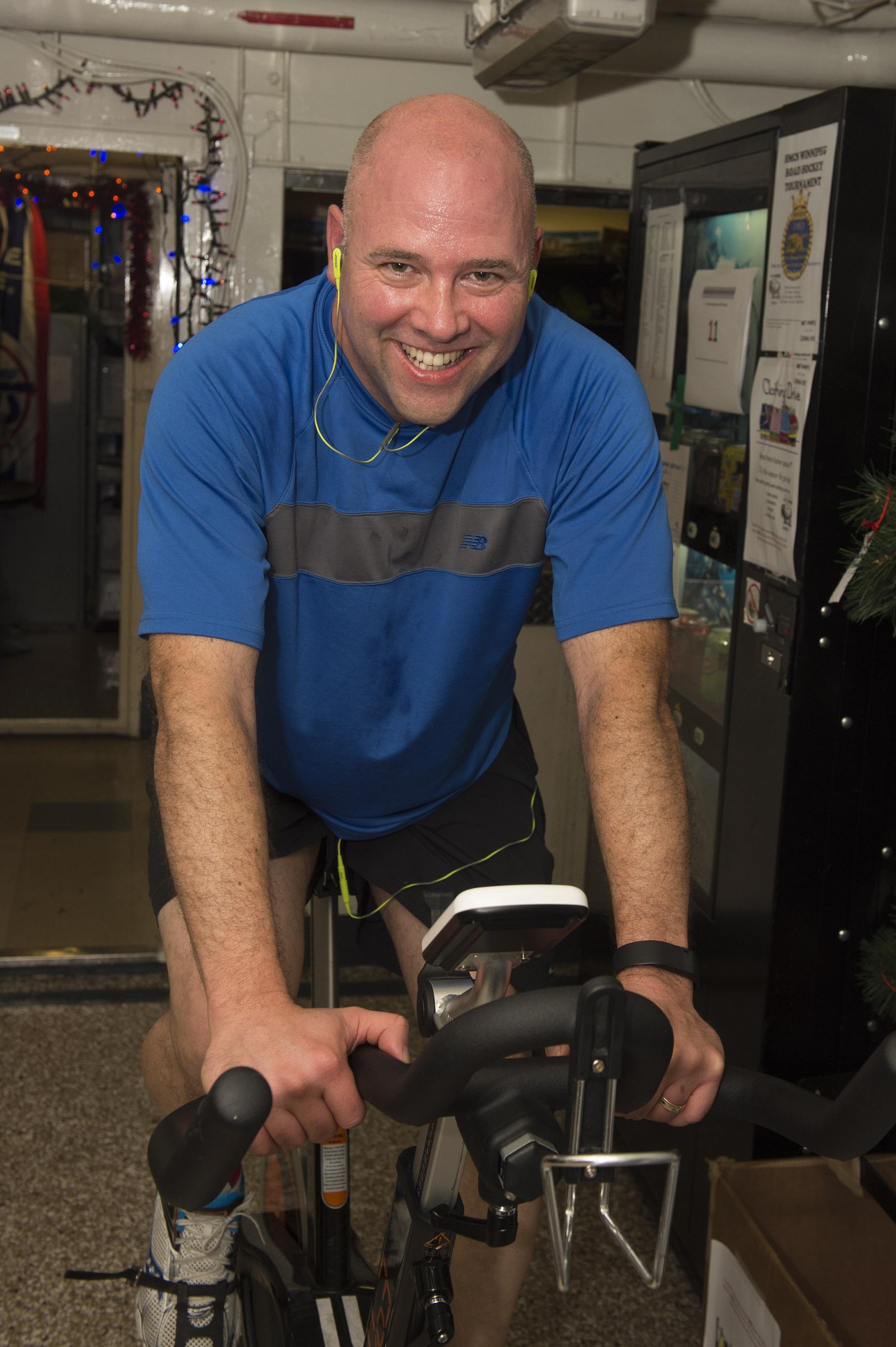 Commander Pascal Belhumeur, the Commanding Officer of HMCS Winnipeg participates in the ship’s Spin-a-Thon fitness challenge during Operation REASSURANCE in the Mediterranean Sea on December 14, 2015.