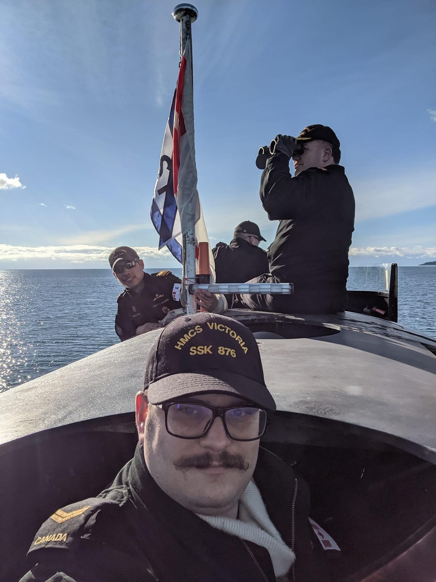 The crew of HMCS Victoria lookout from the submarine while surfaced.