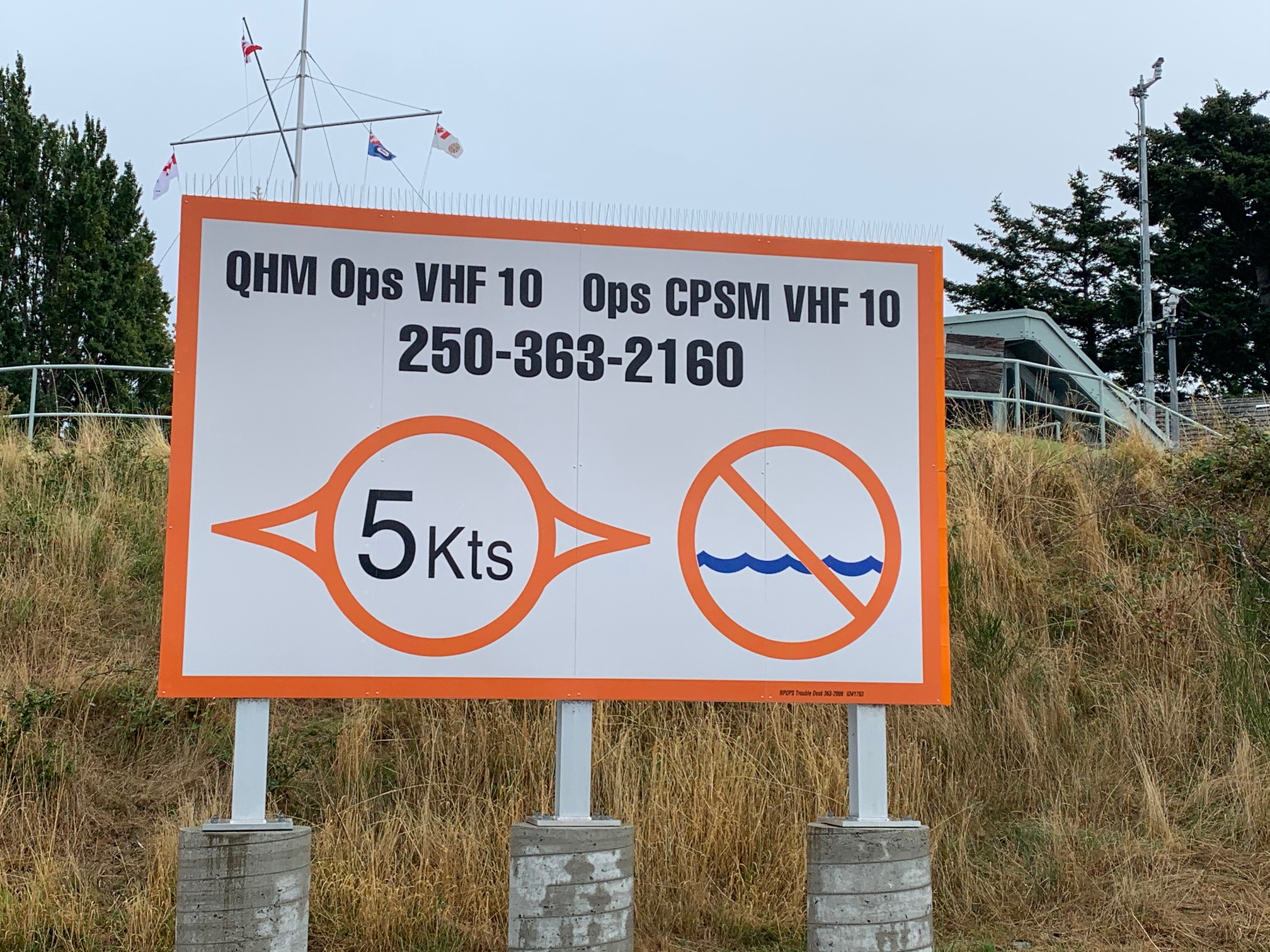 Un panneau indicateur à l’entrée du port d’Esquimalt, en Colombie-Britannique, indique l’obligation de signaler les opérations au capitaine de port de Sa Majesté, afin d’assurer une circulation sécuritaire des navires dans le port.